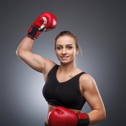 Woman wearing red boxing gloves ready for training, representing Fortira Fit home boxing workouts, strength, confidence, and fitness motivation.