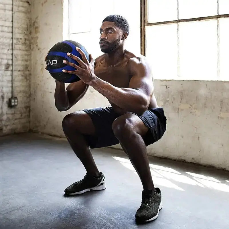 Man doing squat exercise holding a CAP medicine ball during strength training workout